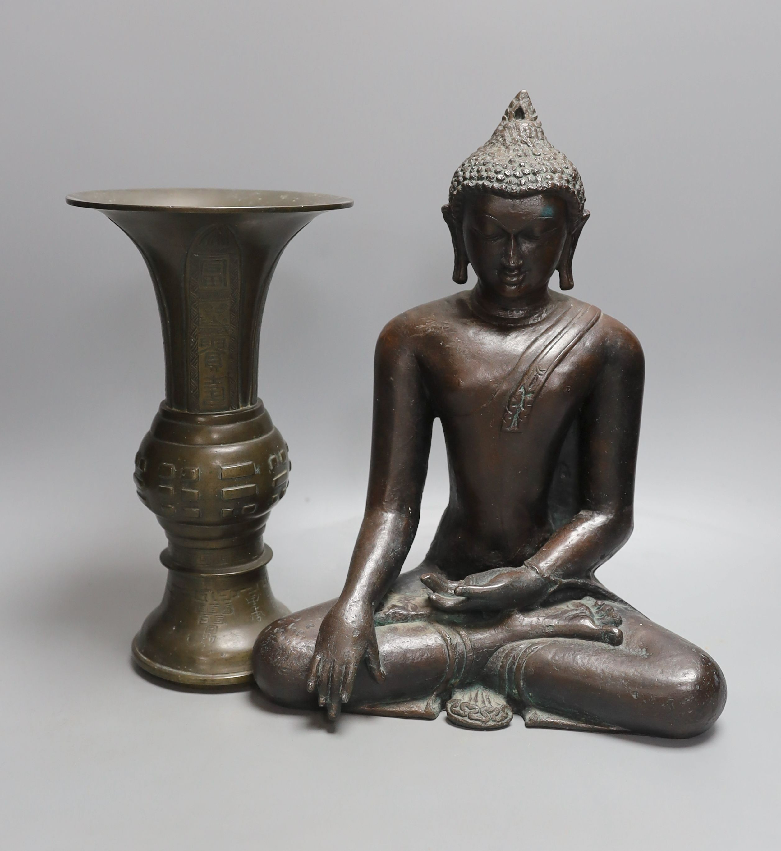 A Chinese bronze vase, 26cm high, inscription to base, together with a bronzed composition seated buddha figure